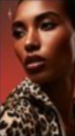 Close-up portrait in a leopard-print coat against deep red